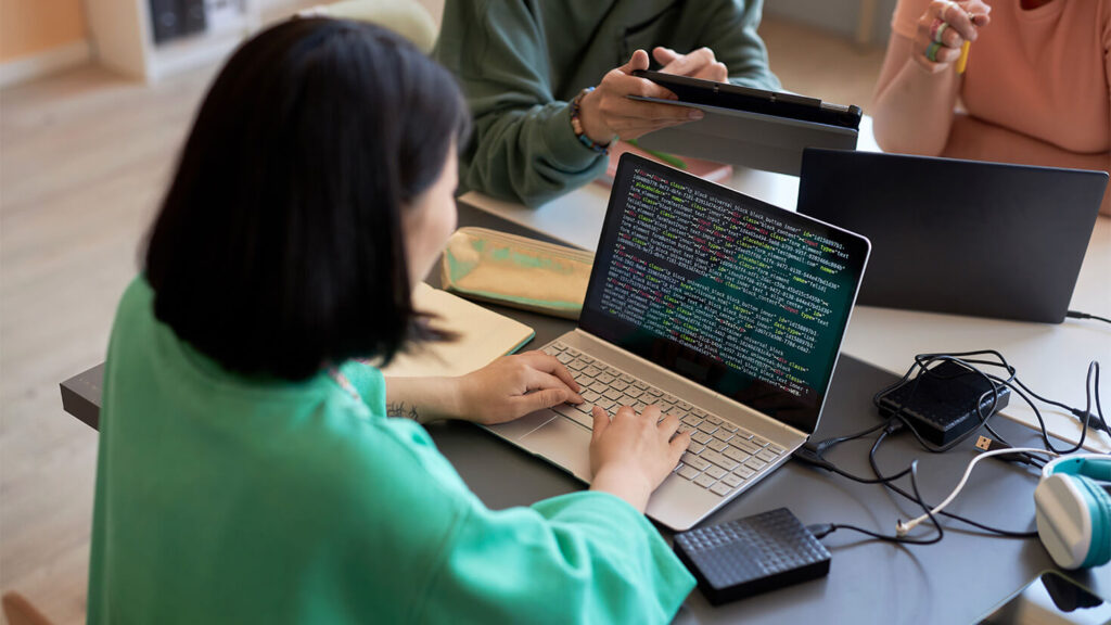 A woman with a laptop writing code